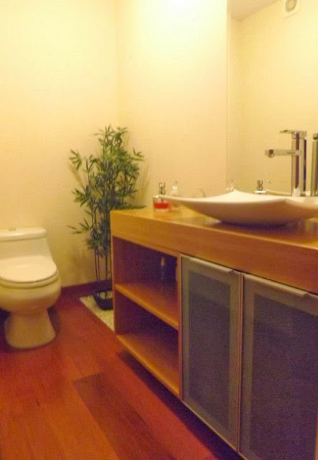 Baño con mueble y piso de madera